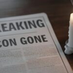 Nashville LOSES Legendary Hit-Maker Behind “The Gambler”… A newspaper with the headline 'BREAKING ICON GONE' next to a lit candle