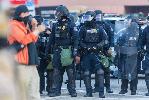 Police officers in riot gear standing in formation during a protest