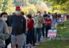 People standing in line for curbside voting on an autumn day