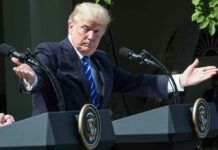 Final Call Haunts Trump After Lindsey Graham’s Shock Death Man speaking at a podium, arms extended outward.