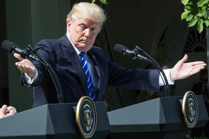 1456093781 Man speaking at a podium, arms extended outward.