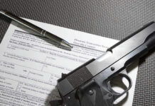 Form with gun and pen on table.