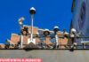 Array of security cameras mounted above a building facade under a clear blue sky