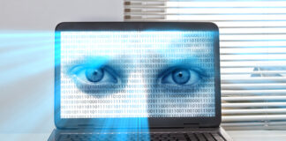 A laptop screen displaying a pair of blue eyes overlaid with binary code