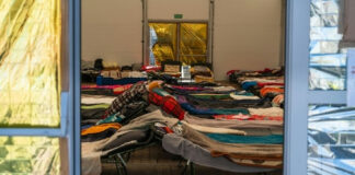 Interior view of a temporary shelter with rows of beds.