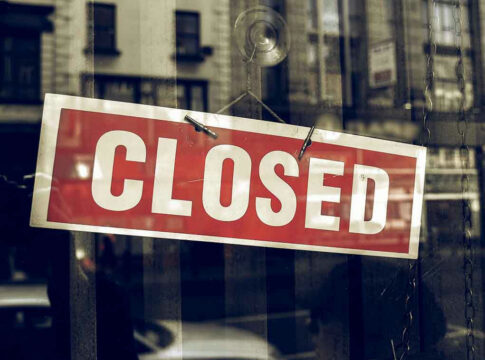 Red closed sign hanging in a window.