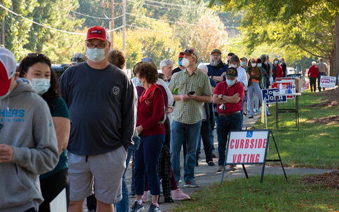 People standing in line for curbside voting on an autumn day